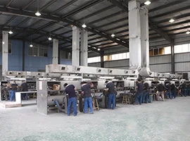 Workers assembling towel warmers in a large factory