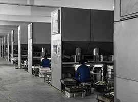 Workers operating molding machines in a production line