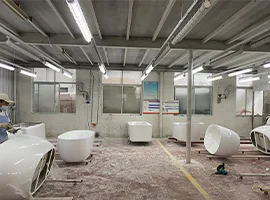 Workers finishing bathtubs in a factory workshop