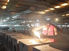 Factory worker inspecting toilet ceramics under bright light